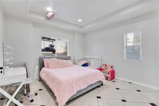 bedroom with tile patterned floors and a tray ceiling