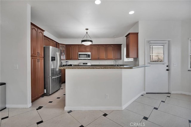 kitchen featuring light tile patterned floors, kitchen peninsula, appliances with stainless steel finishes, and pendant lighting