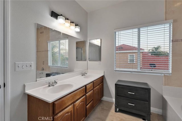 bathroom with plenty of natural light, a bathtub, and vanity