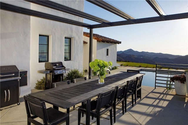 view of patio featuring a pergola, a mountain view, and area for grilling