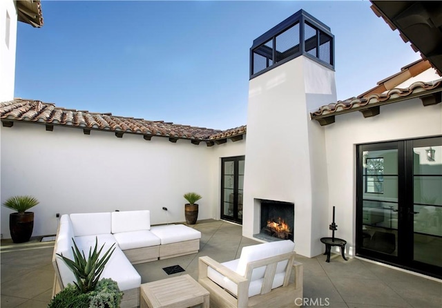 view of patio featuring an outdoor living space with a fireplace and french doors