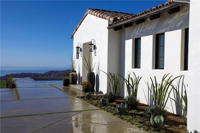 view of side of property featuring a patio area and a mountain view