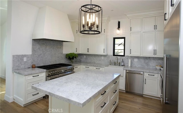 kitchen featuring pendant lighting, custom exhaust hood, an inviting chandelier, white cabinetry, and appliances with stainless steel finishes