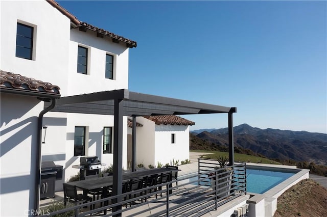 exterior space with a mountain view, area for grilling, and a pergola