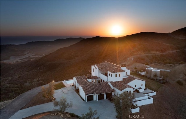 aerial view at dusk featuring a mountain view