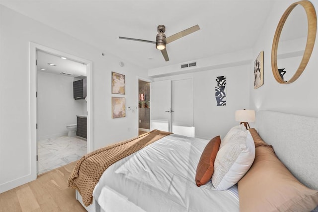 bedroom featuring ceiling fan, connected bathroom, and light hardwood / wood-style flooring