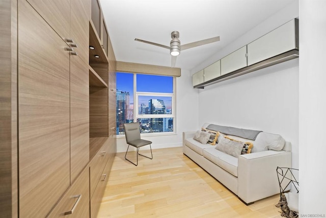 sitting room with ceiling fan and light hardwood / wood-style flooring