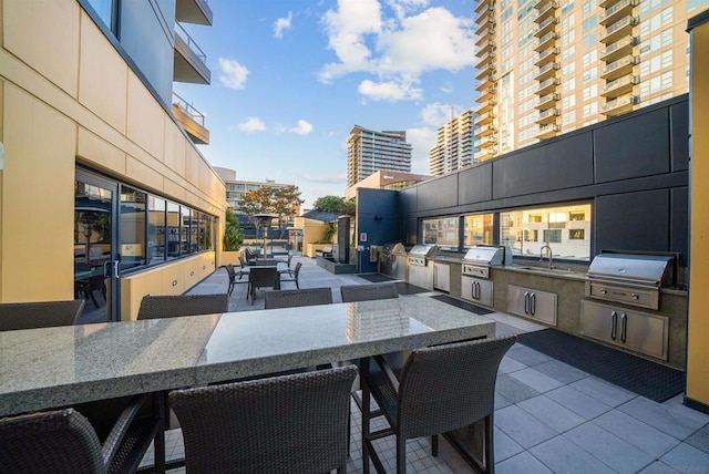 view of patio featuring exterior kitchen, an outdoor wet bar, and area for grilling