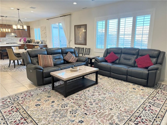 tiled living room with an inviting chandelier