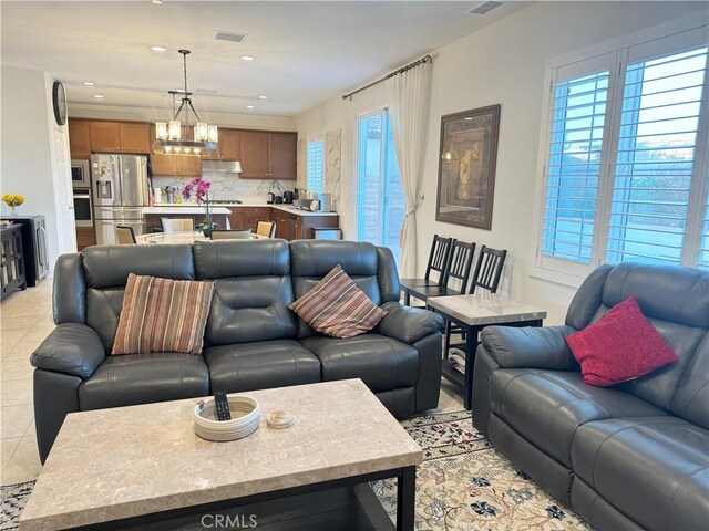 living room with an inviting chandelier and light tile patterned floors