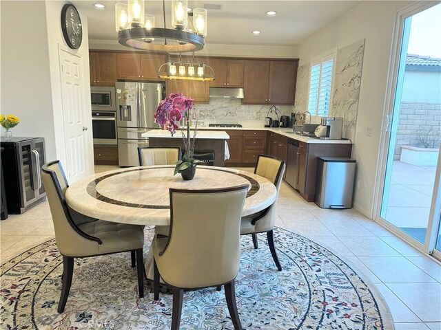 tiled dining area featuring a chandelier and wine cooler