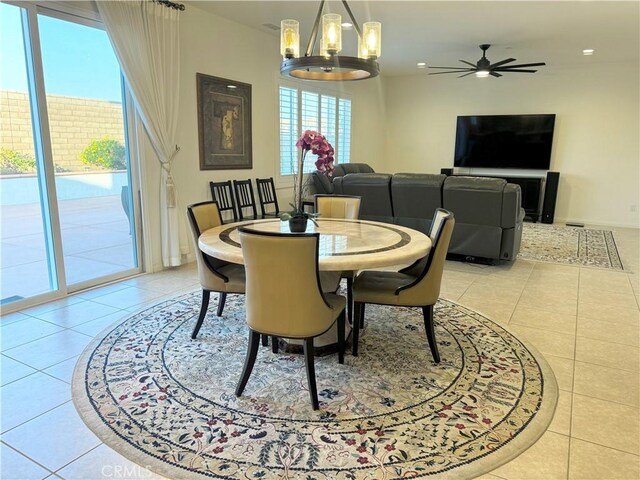 tiled dining area featuring ceiling fan with notable chandelier and a wealth of natural light