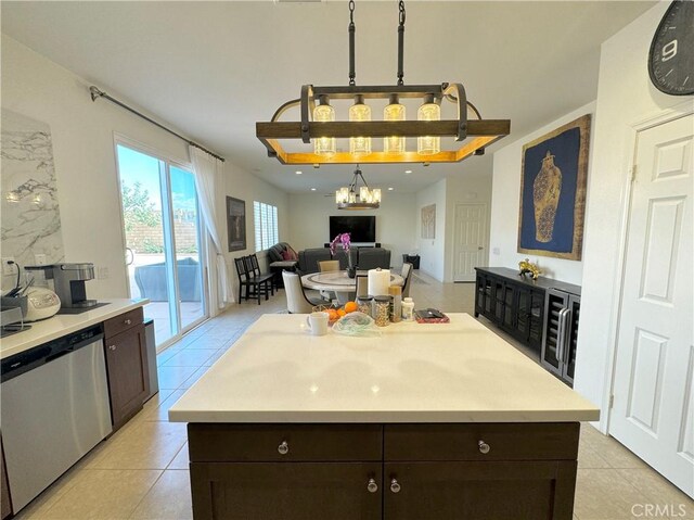 kitchen featuring dark brown cabinets, a center island, light tile patterned floors, and stainless steel dishwasher