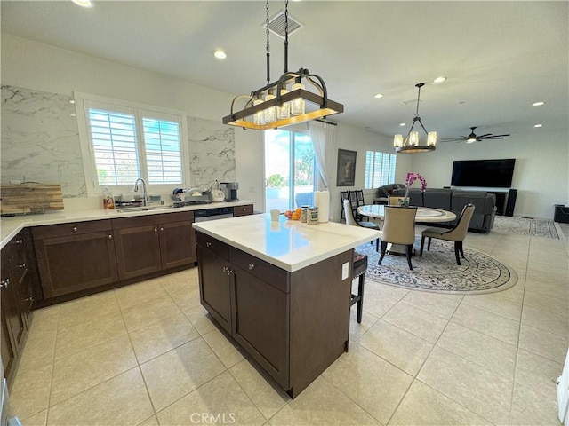 kitchen featuring sink, light tile patterned floors, hanging light fixtures, and a kitchen island