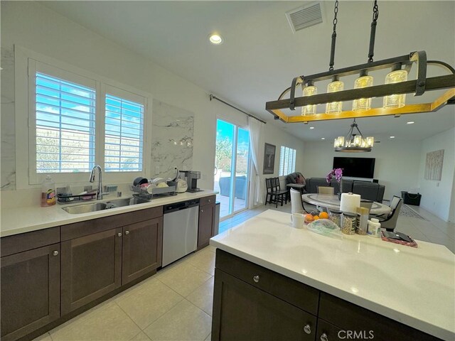 kitchen with decorative light fixtures, sink, stainless steel dishwasher, and plenty of natural light