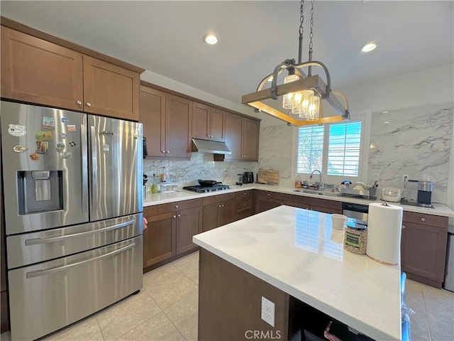 kitchen featuring sink, decorative backsplash, hanging light fixtures, and appliances with stainless steel finishes