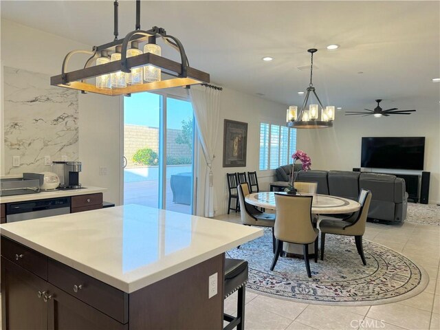 kitchen featuring dark brown cabinets, dishwasher, hanging light fixtures, light tile patterned floors, and a center island