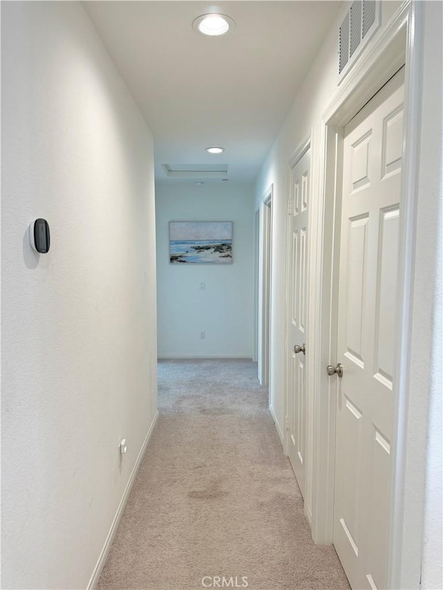 hall featuring light colored carpet