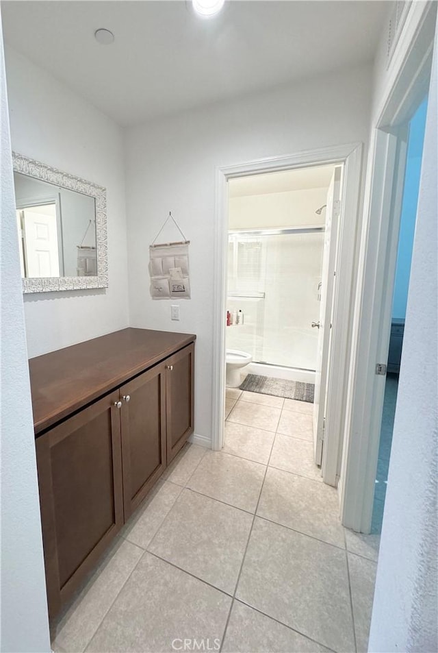 bathroom with toilet, walk in shower, tile patterned floors, and vanity