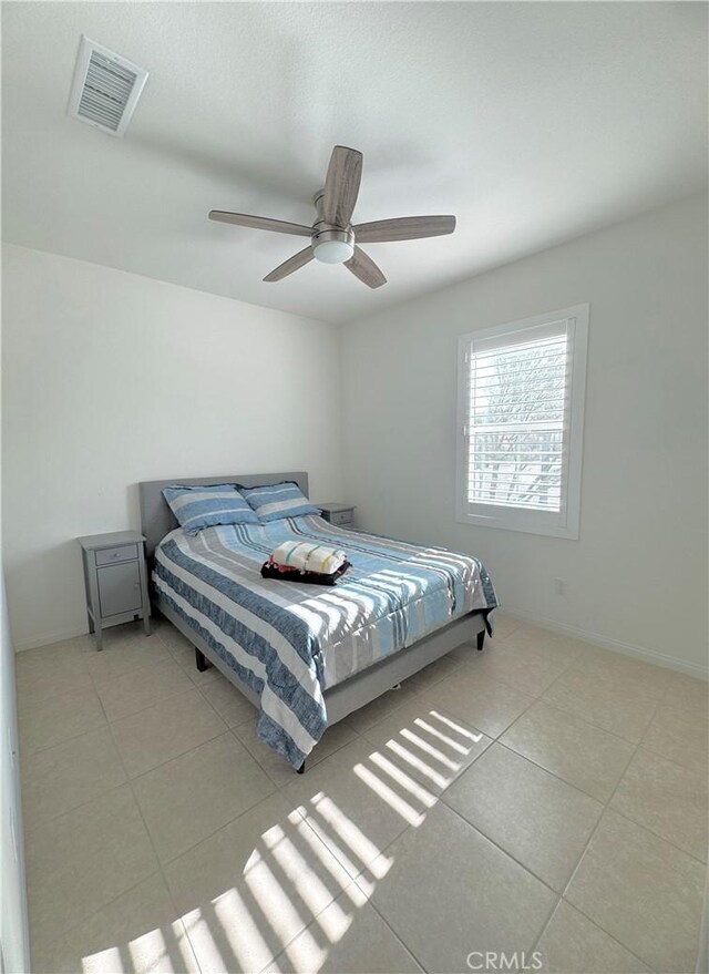 tiled bedroom featuring ceiling fan