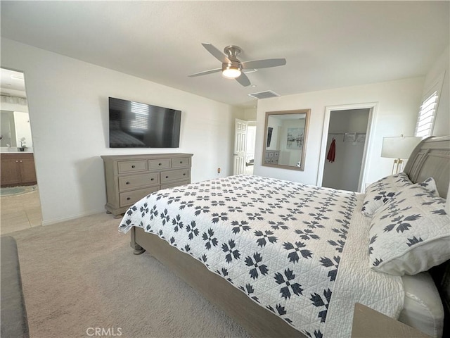 carpeted bedroom with ceiling fan, ensuite bathroom, a closet, and a spacious closet