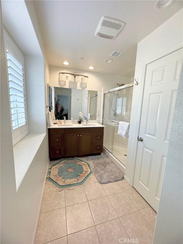 bathroom featuring vanity, a shower with door, and tile patterned flooring