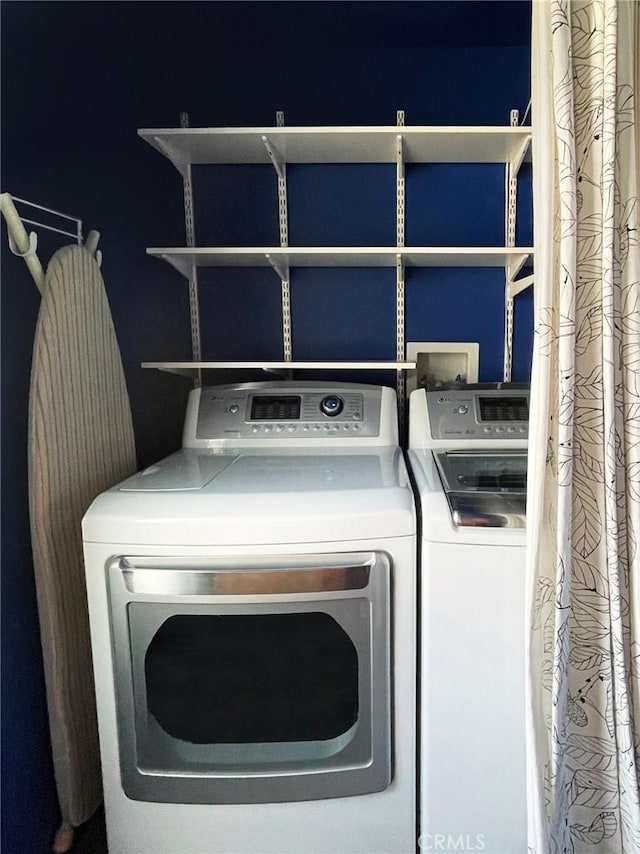 clothes washing area with washing machine and dryer