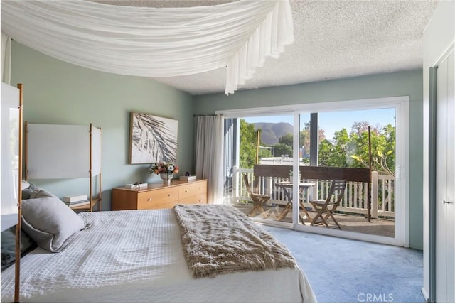 bedroom with carpet floors, access to exterior, multiple windows, and a textured ceiling