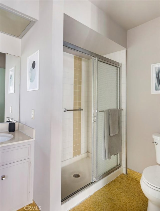 bathroom featuring toilet, an enclosed shower, and vanity