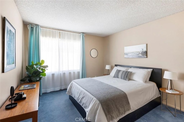 bedroom featuring a textured ceiling and dark colored carpet