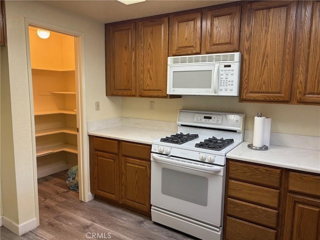 kitchen featuring dark hardwood / wood-style flooring and white appliances