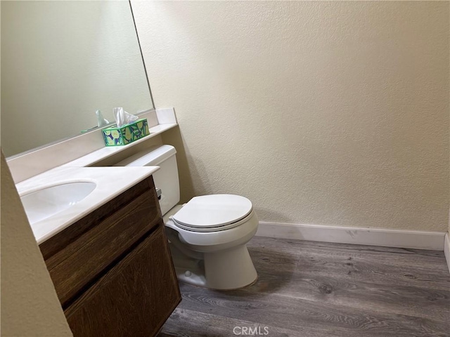 bathroom featuring toilet, wood-type flooring, and vanity