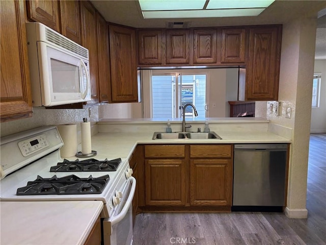 kitchen with sink, dark hardwood / wood-style floors, and white appliances