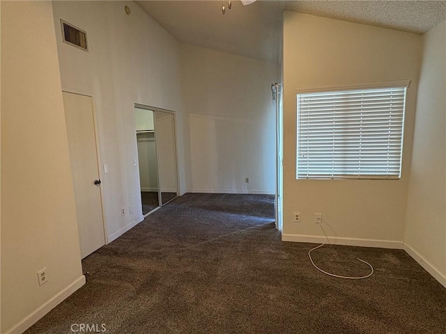 carpeted spare room featuring lofted ceiling