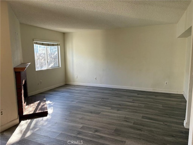 unfurnished living room with a textured ceiling and dark hardwood / wood-style floors