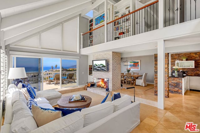 tiled living room with a fireplace and a high ceiling