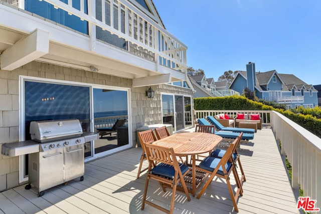 wooden terrace with a grill and an outdoor living space