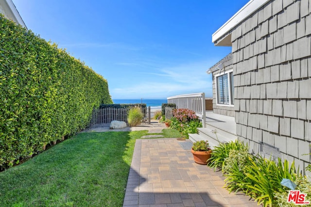 view of yard featuring a water view and a patio area