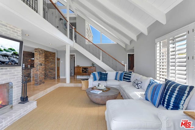 living room featuring high vaulted ceiling, beamed ceiling, and a fireplace