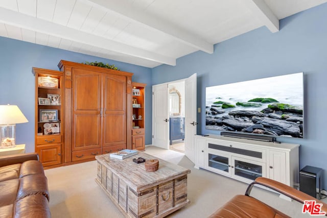 carpeted living room with beamed ceiling