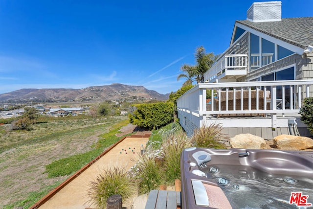 exterior space with a mountain view and a hot tub