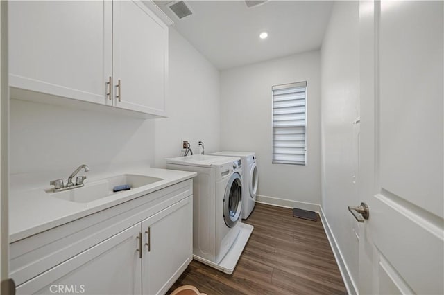 clothes washing area featuring cabinets, sink, dark hardwood / wood-style flooring, and independent washer and dryer