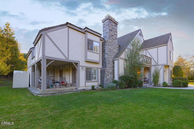 rear view of property featuring a lawn and a balcony