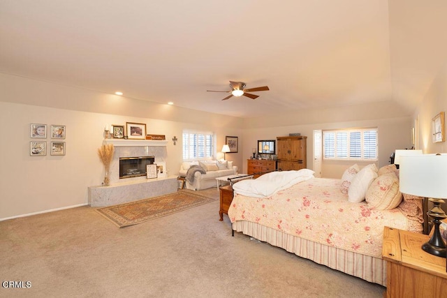 carpeted bedroom featuring a premium fireplace and ceiling fan