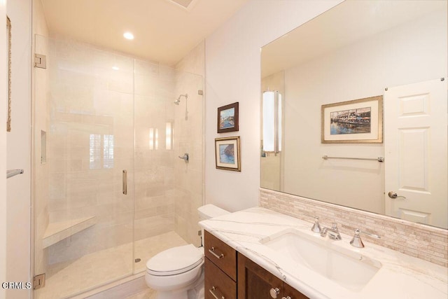 bathroom featuring decorative backsplash, toilet, walk in shower, and vanity