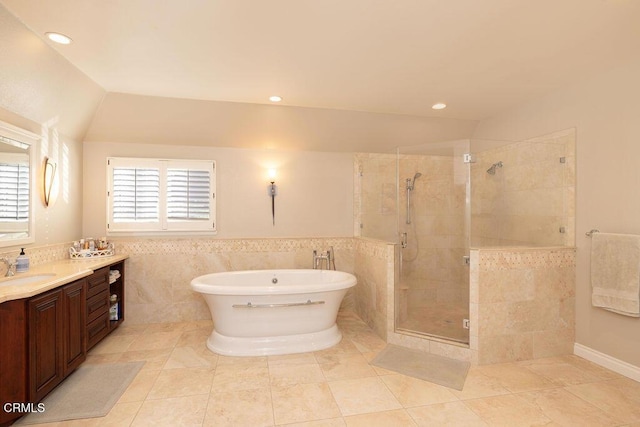 bathroom with separate shower and tub, tile walls, tile patterned floors, vaulted ceiling, and vanity