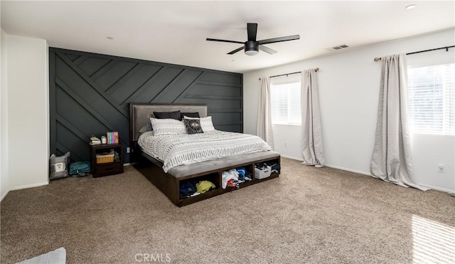 carpeted bedroom featuring ceiling fan and multiple windows