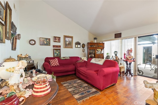 living room featuring lofted ceiling and hardwood / wood-style flooring