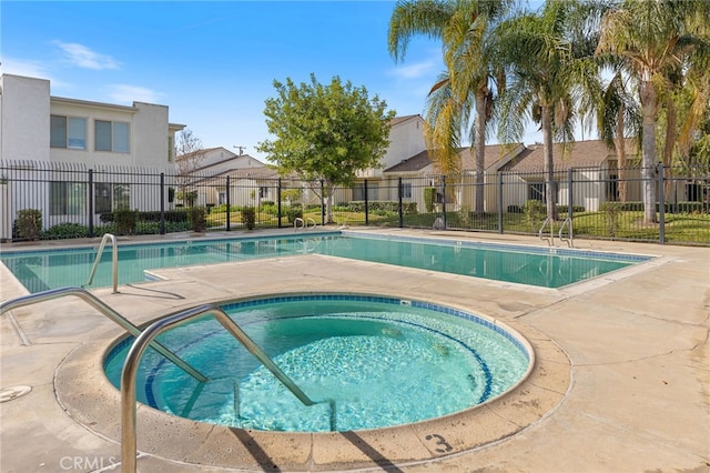 view of swimming pool featuring a hot tub