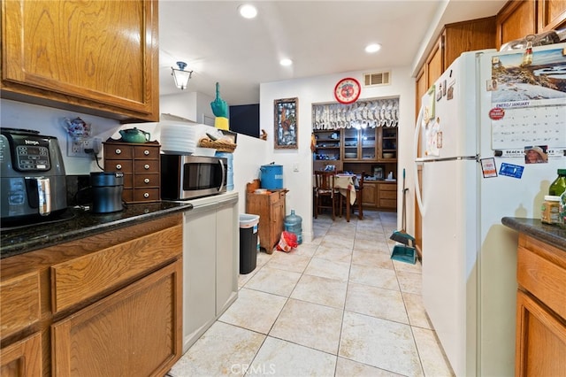 kitchen with light tile patterned floors and white fridge